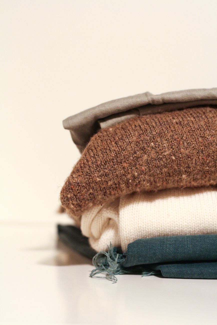 Pila de sweaters de lana doblados mostrando distintas texturas y capas